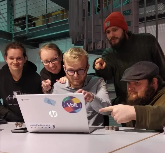 The GRIMA team gathered around a laptop