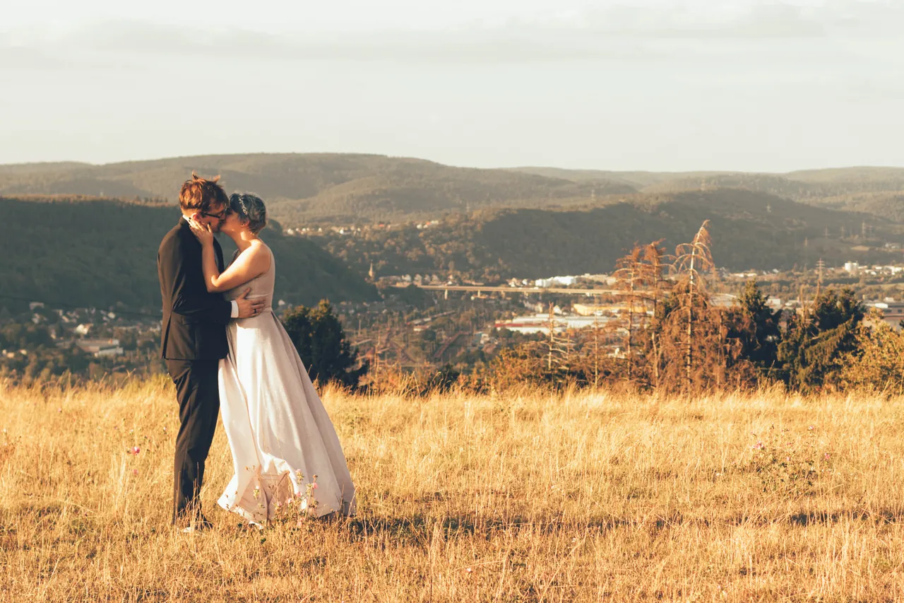 Wedding couple in a golden meadow above the valley